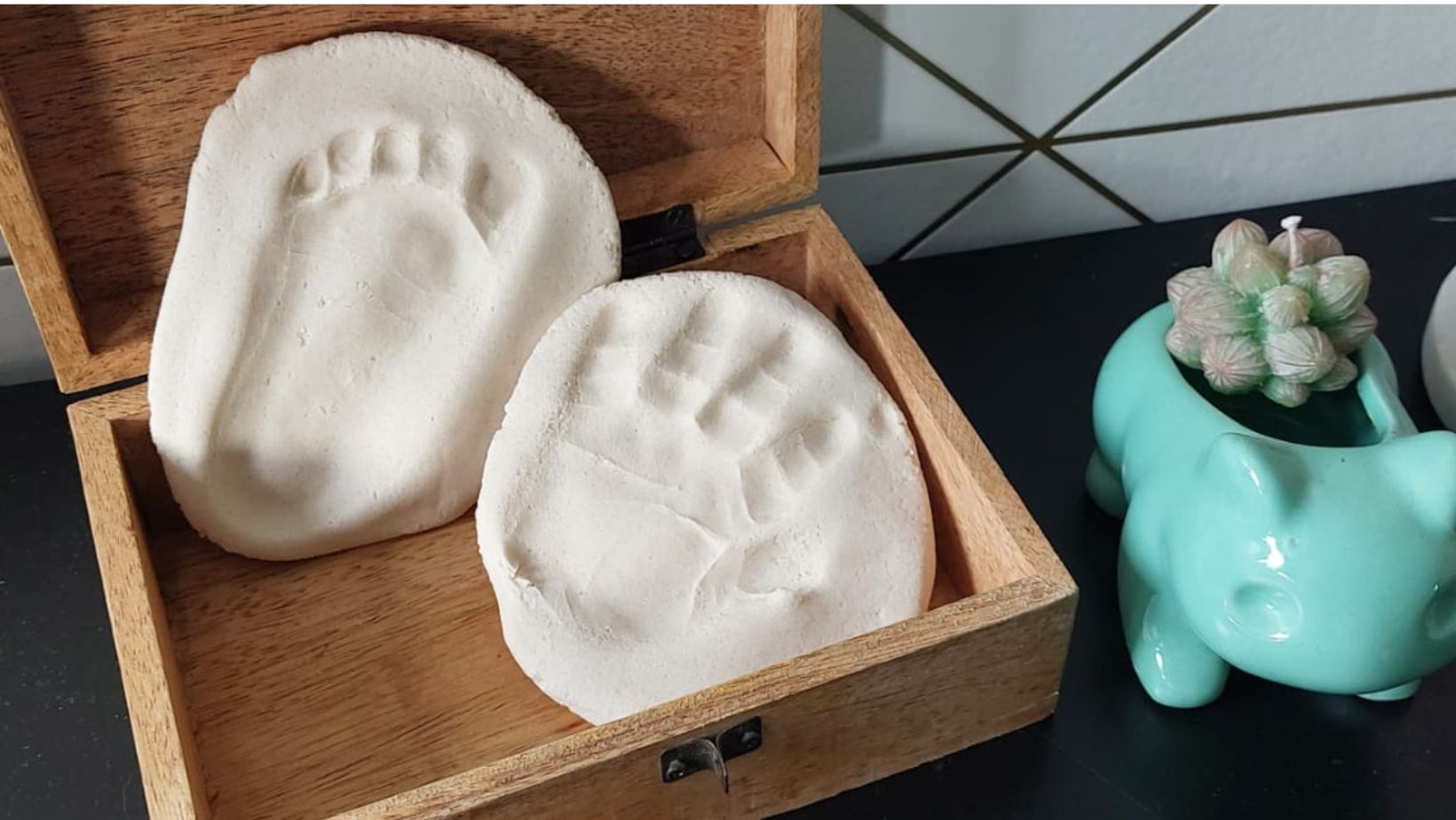 Voorbeeld van afdrukken van voetjes in zoutdeeg in een houten kistje.