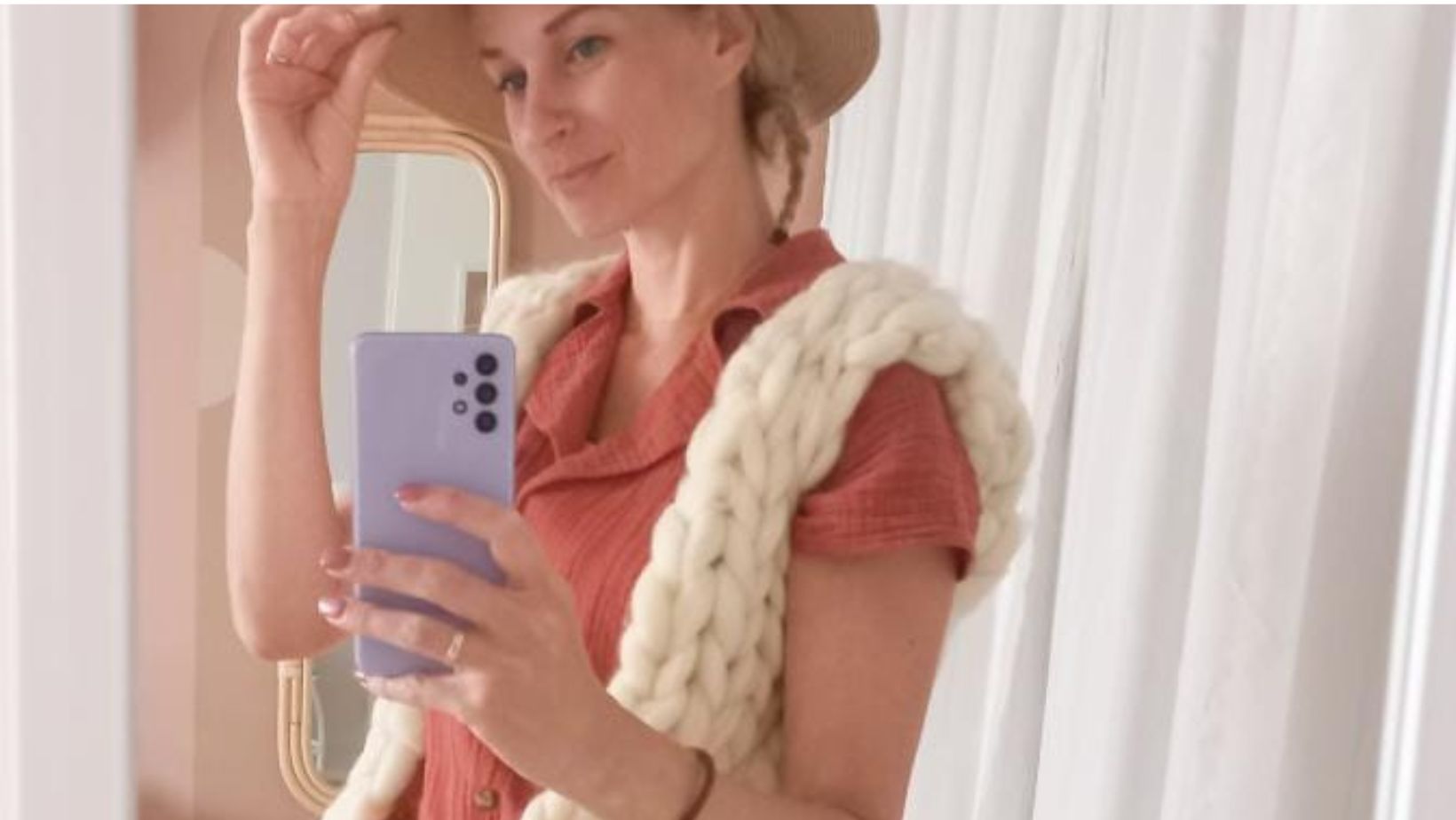 Selfie met een hoed op, en een vest van lontwol in de spiegel.