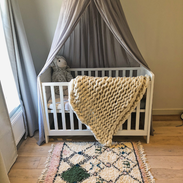 Lontwol deken breien in Ivory voor een babykamer.