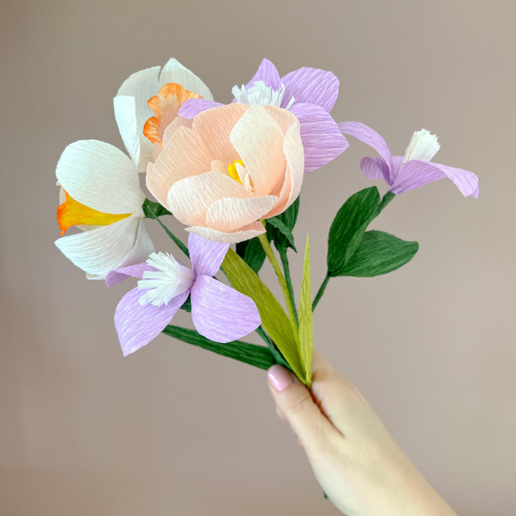 DIY pakket bloemen van crepe papier vastgehouden in een hand.