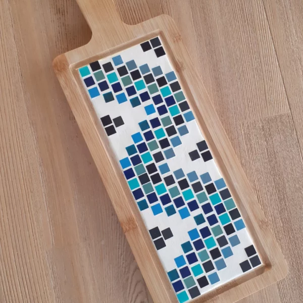 Borrelplank van bamboe hout op tafel gemaakt met mozaïek steentjes in blauwtinten en wit.