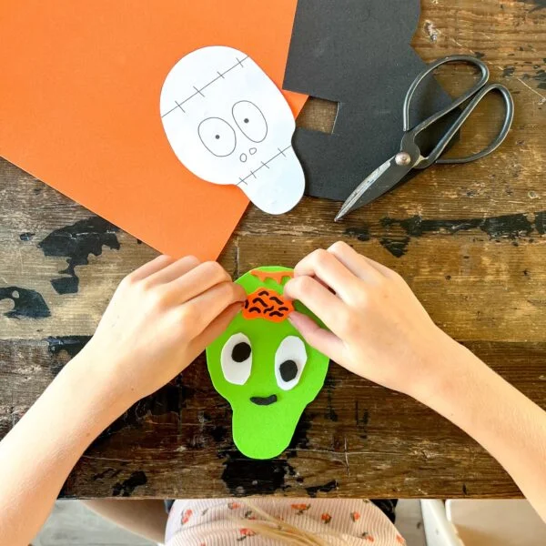 Een groen monster gemaakt van foam en wiebeloogjes.
