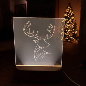 Een LED krasplaat met een hert erop gegraveerd ter decoratie voor de kerst als DIY pakket.