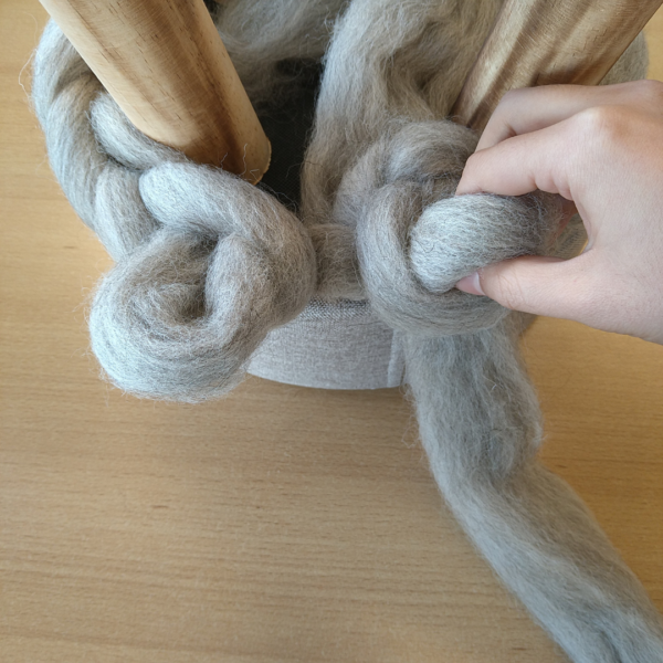 Voorbeeld hoe je met de hand stap voor stap een hoes kunt breien voor een krukje met dikke wol.