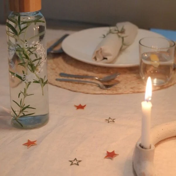 Tafel feestelijk gedekt met de DIY handlettering karaf, kaars, bord bestek en servet.