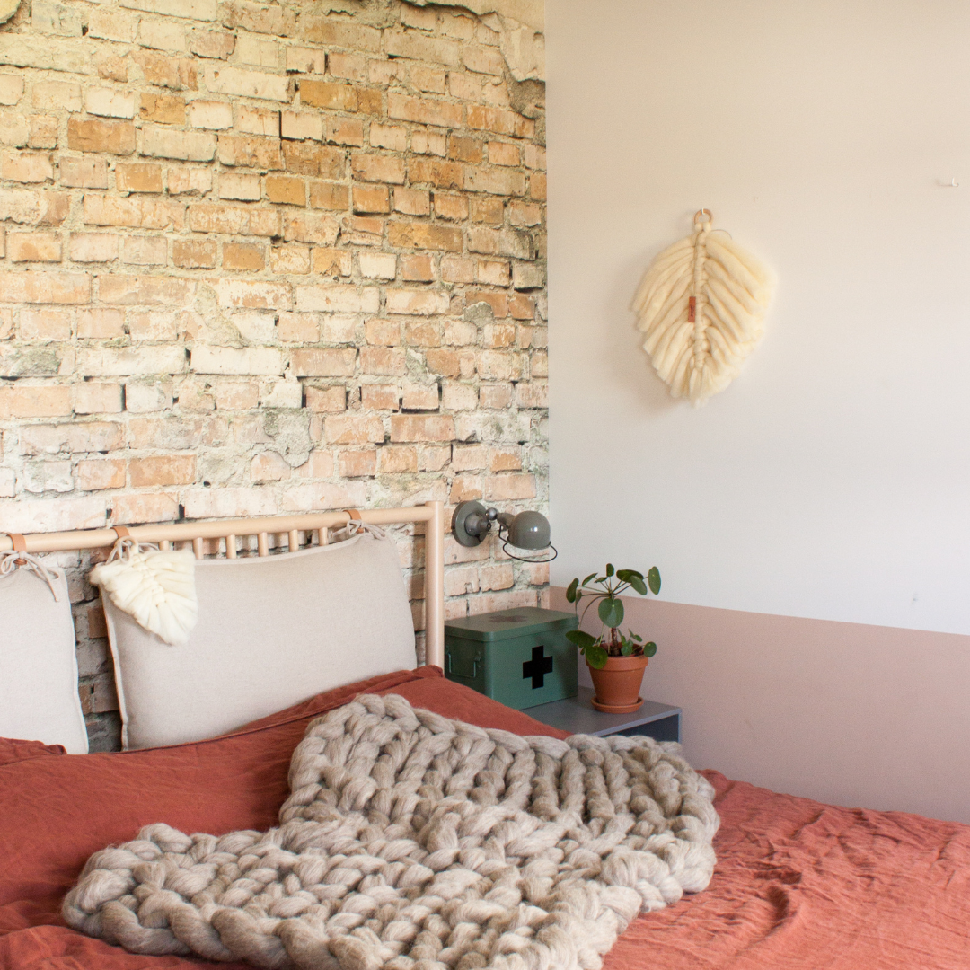 Veer van lontwol macrame aan de wand, met een woondeken van lontwol over het bed.