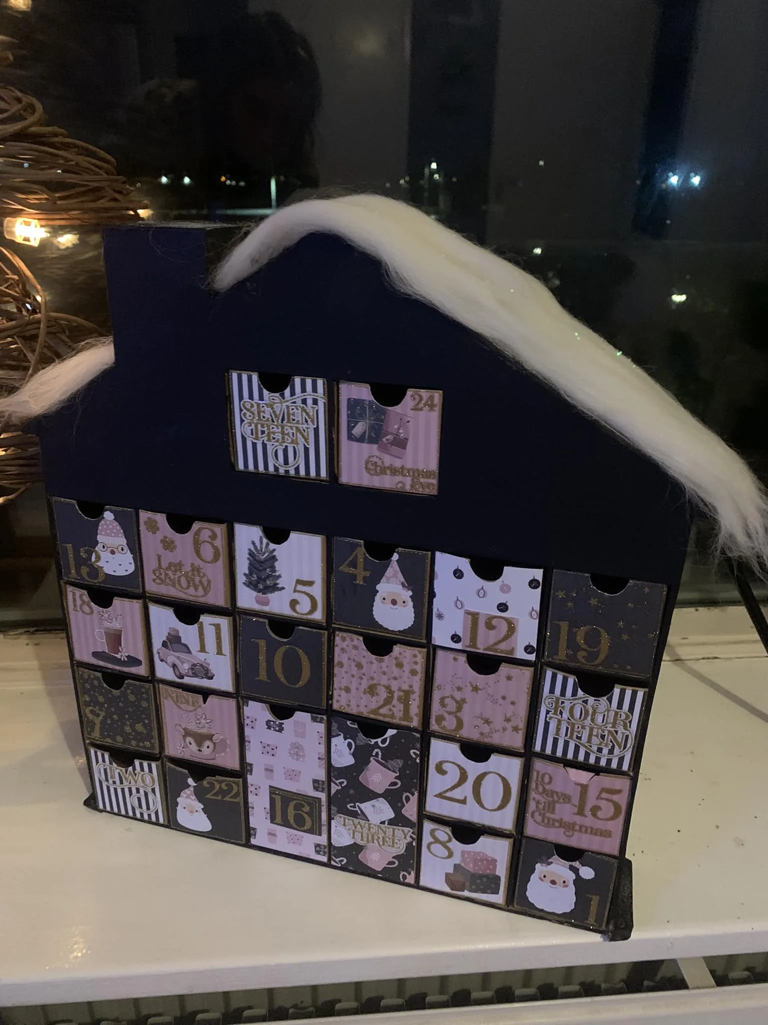 Voorbeeld advent knutsel huis kalender met zwart, roze en lontwol op het dak.