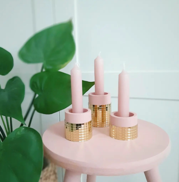 Roze kaarsen in een roze kaarsenhouder met discostrip in goud.