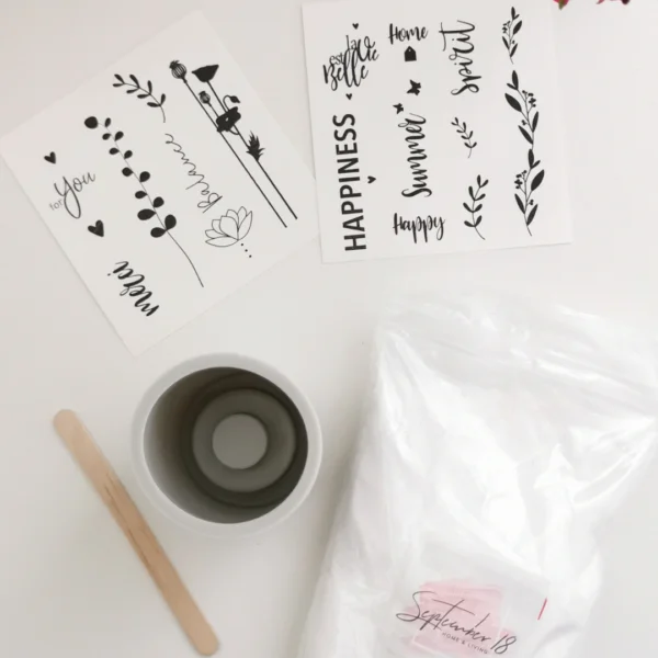 Inhoud van het DIY raysin kaarsenhouders pakket; de mal om te gieten, de Raysin poeder, een houten roerstokje en decoratie stickers.