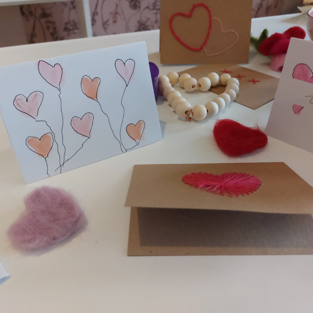 Valentijns kaarten DIY met geverfde kaarten, gevilte hartjes en houten kralen in een hartje gemaakt met ijzerdraad.