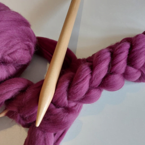 Kussen breien met aubergine paarse lontwol op XXL houten pennen.