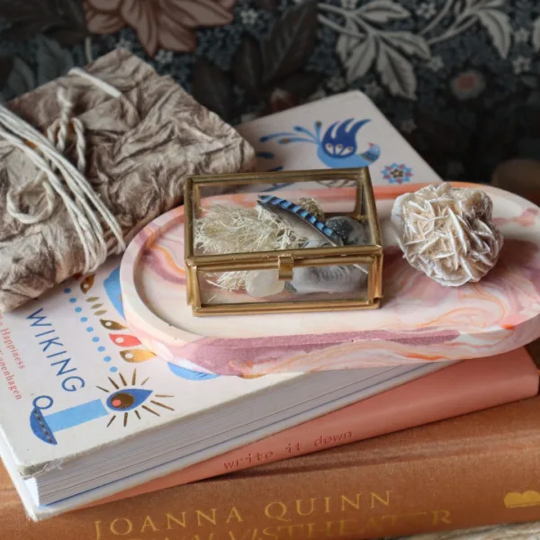 Jesmonite schaaltje in aardetinten op een houten tafeltje met boeken en een ingebonden boek van vilt.