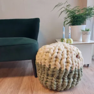 Lontwol poef gebreid met Ivory en Wedgewood groen, met een groen bankje, tafel met planten en kaarsen.