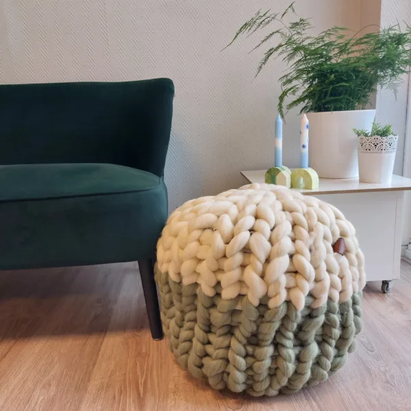 Lontwol poef gebreid met Ivory en Wedgewood groen, met een groen bankje, tafel met planten en kaarsen.