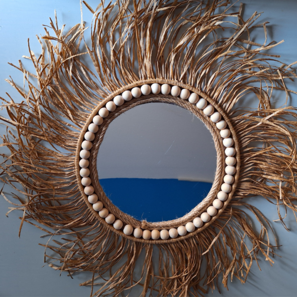 Ronde spiegel met houten kralen en raffia.