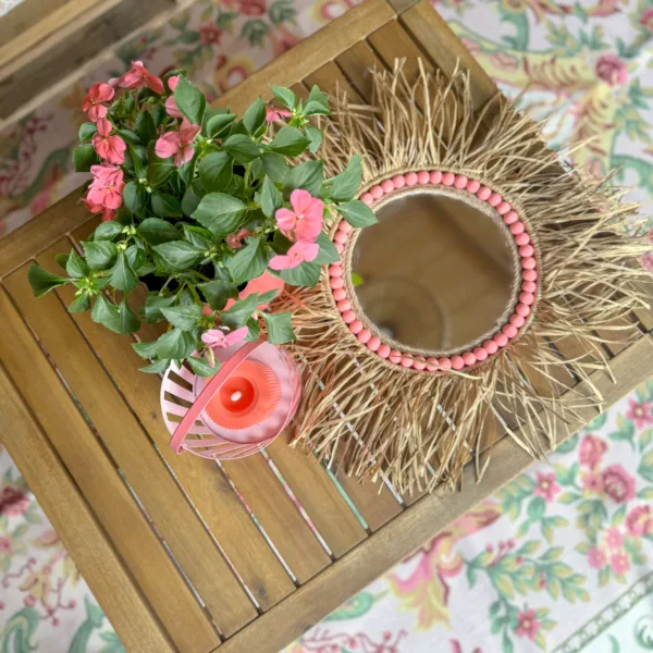 Spiegel met raffia met zomerse houten en roze accessoires.