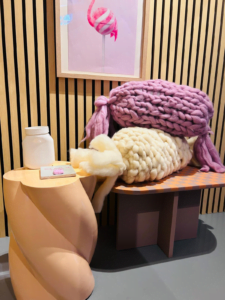 Twee gebreide kussens samen in de vorm van een snoepje, in blush en Ivory.