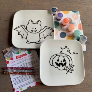 Stippen op servies met het bordje vleermuis en pompoen voor Halloween.