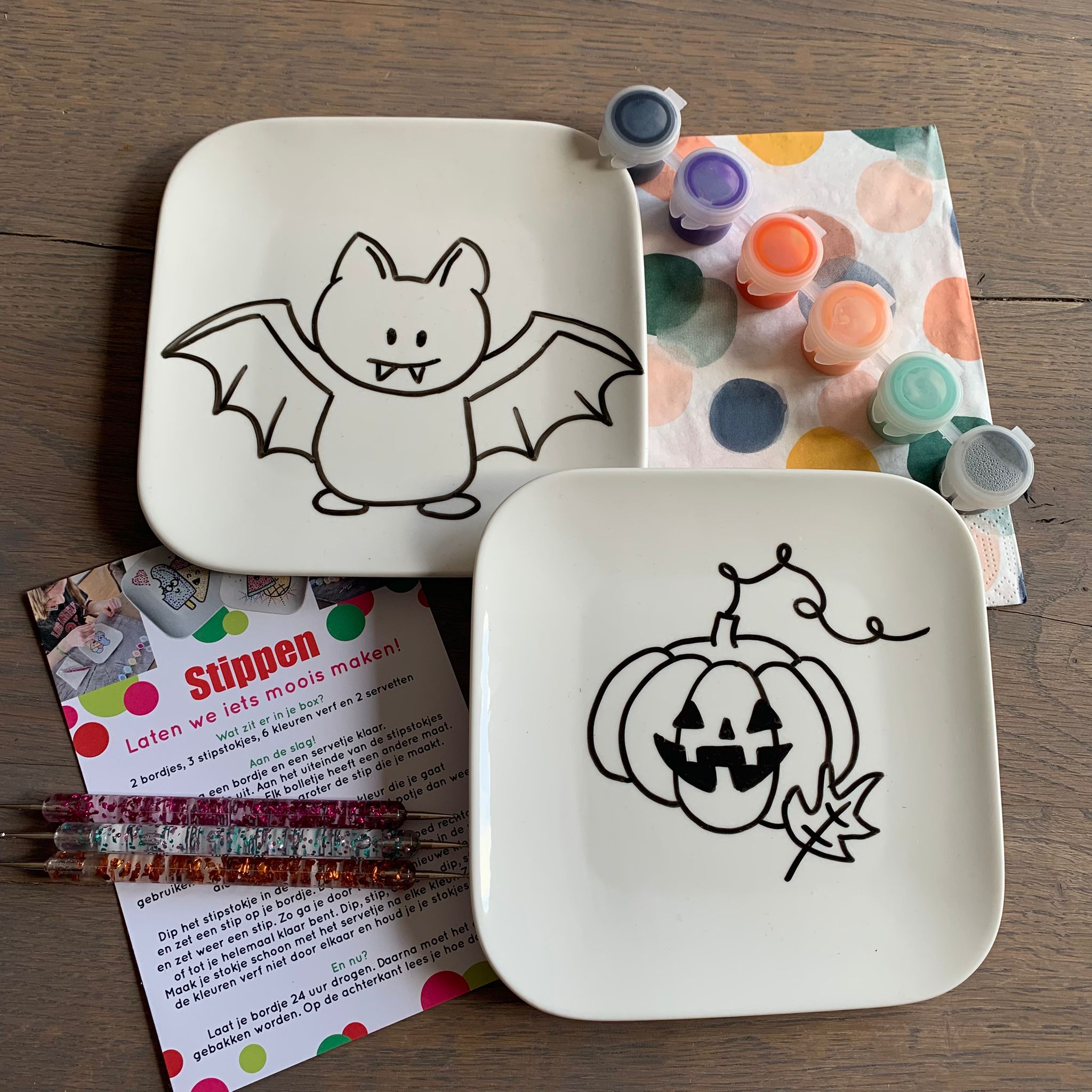 Stippen op servies met het bordje vleermuis en pompoen voor Halloween.