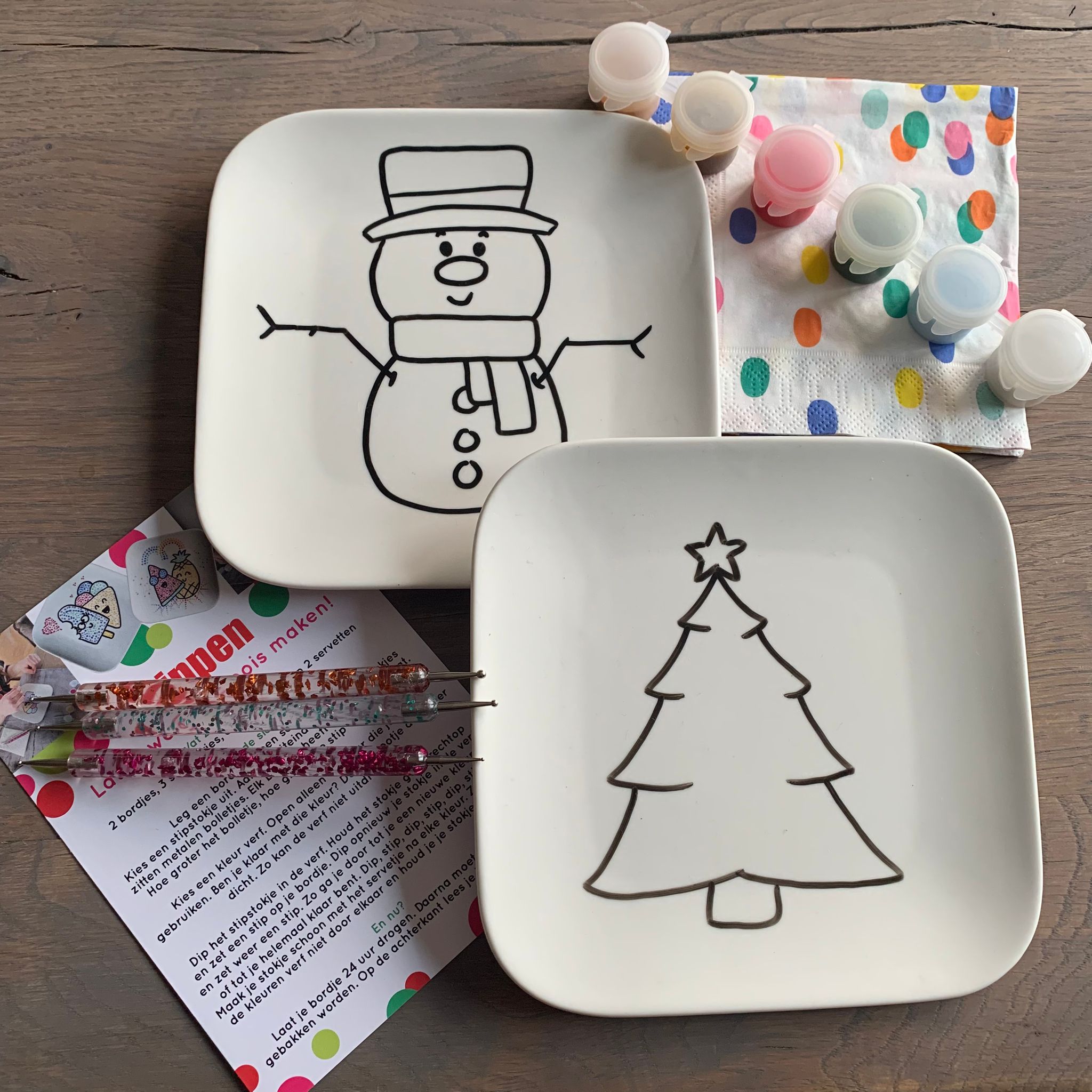 Stippen op servies met het bordje sneeuwpop en kerstboom.