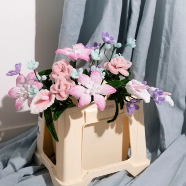 Emmer gevuld met zelf gemaakte bloemen van chenille.