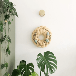 Paaskrans met zachtgele lontwol en Paas decoratie aan de wand.