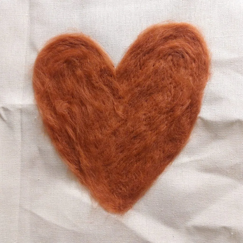 Hart van lontwol luchtig gevilt met prikvilten op een canvas doek.