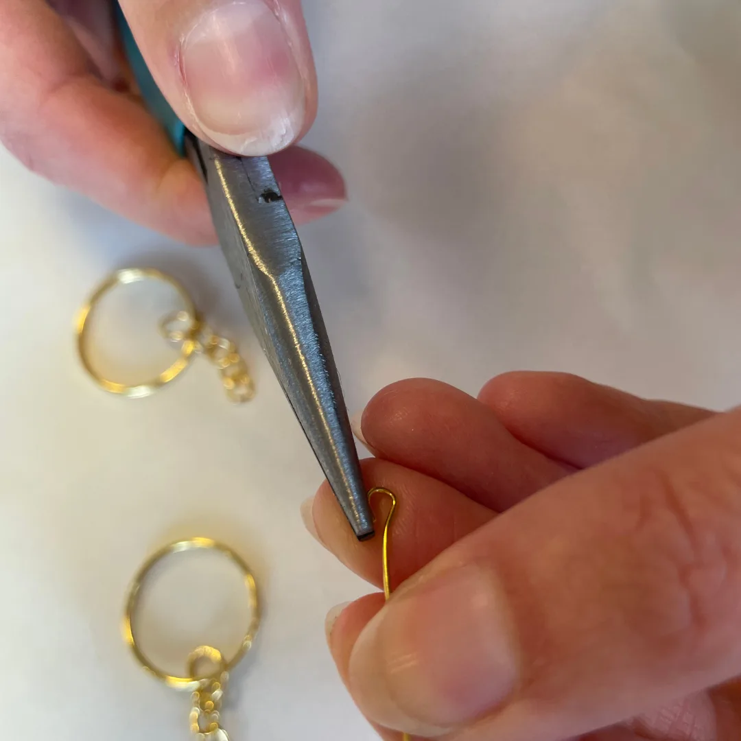 Maak de eye pin open met een speciale sieraden tang om de sleutelhanger te bevestigen.