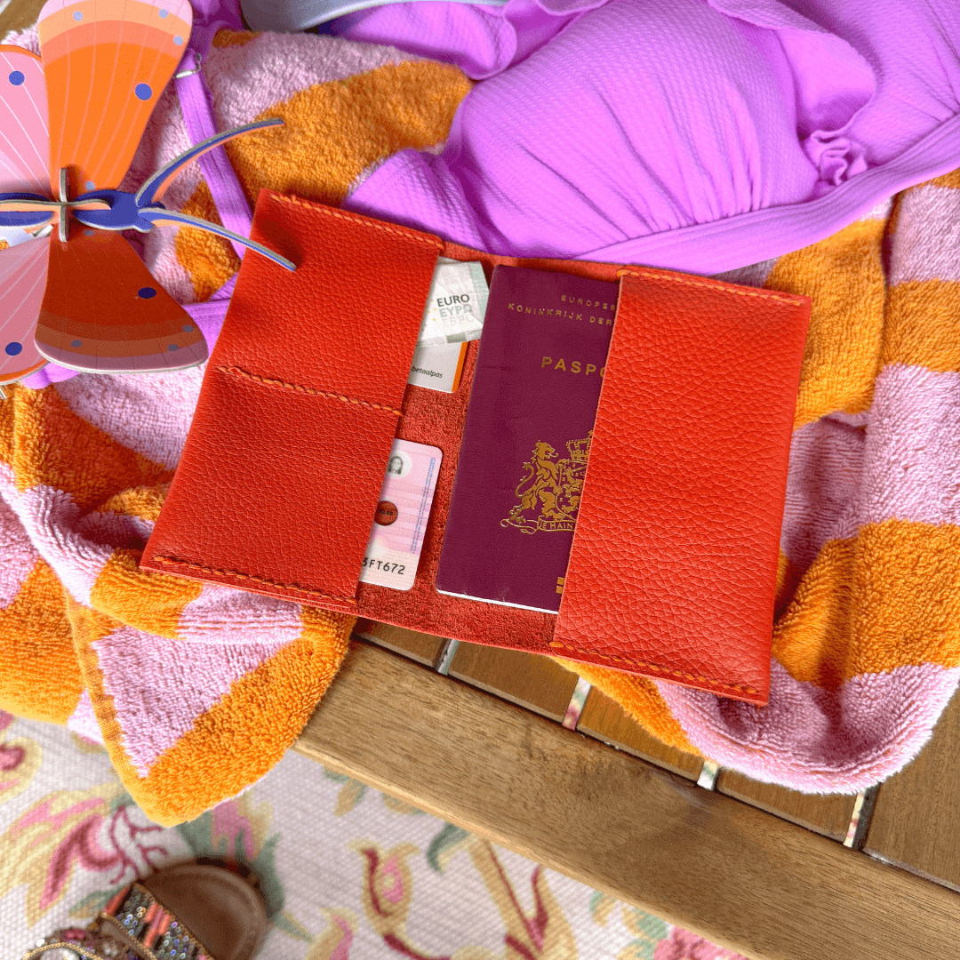 Koffer op reis met paspoorthoesje en zomerse kleding.