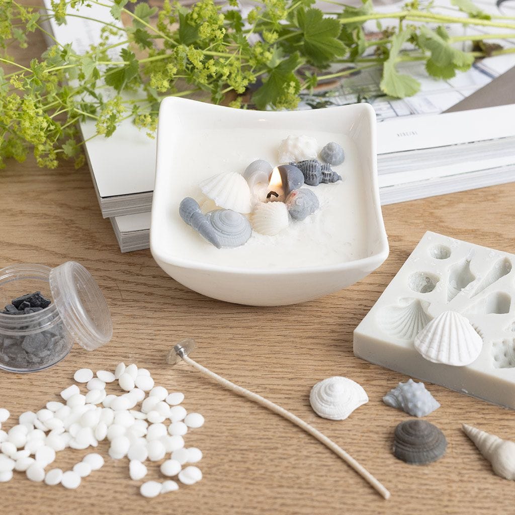 Soja was kaars in een schaaltje met schelpen.