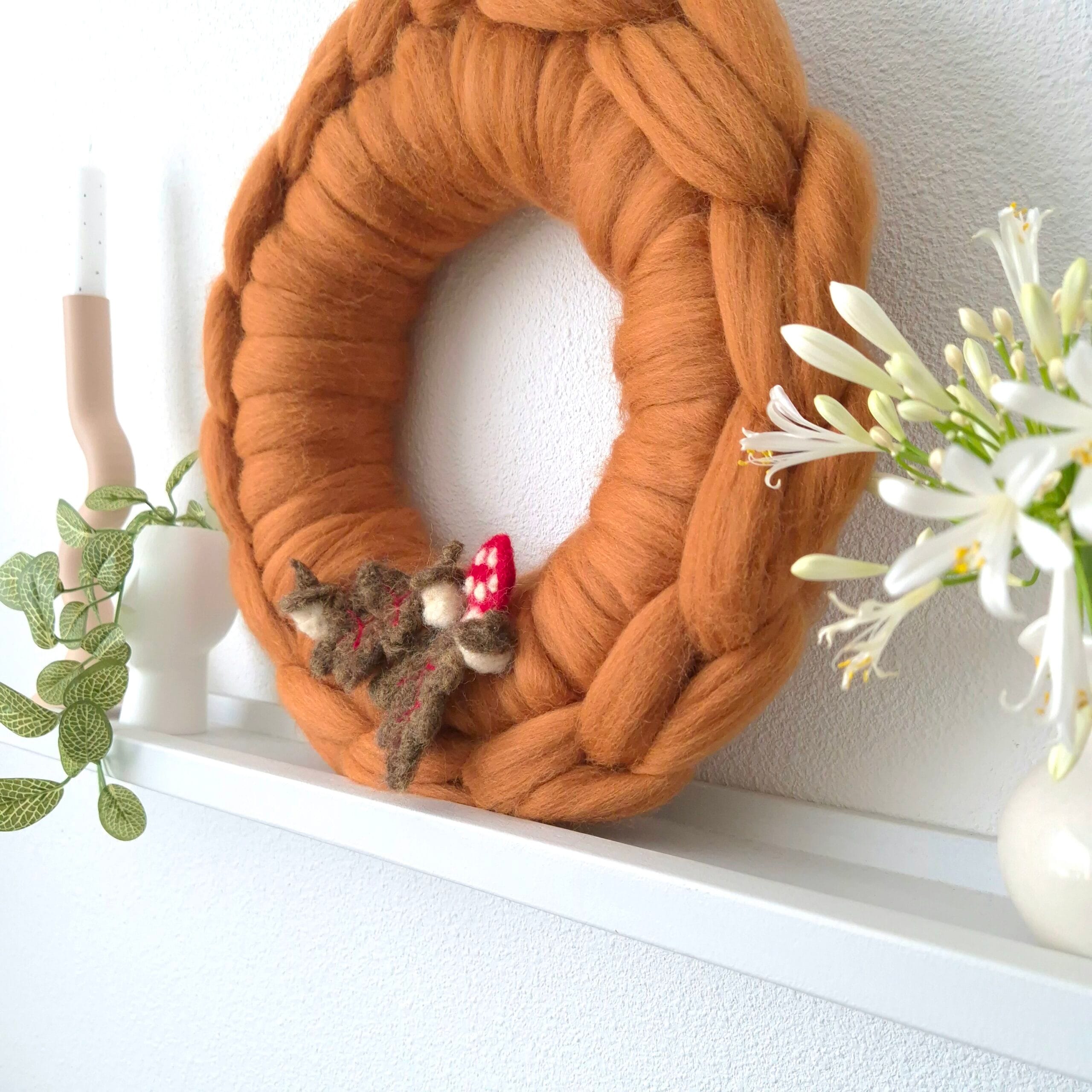 Herfstkrans met lontwol, in de kleur fox, met details geprikvilt zoals een paddenstoel, blaadje en eikeltjes.