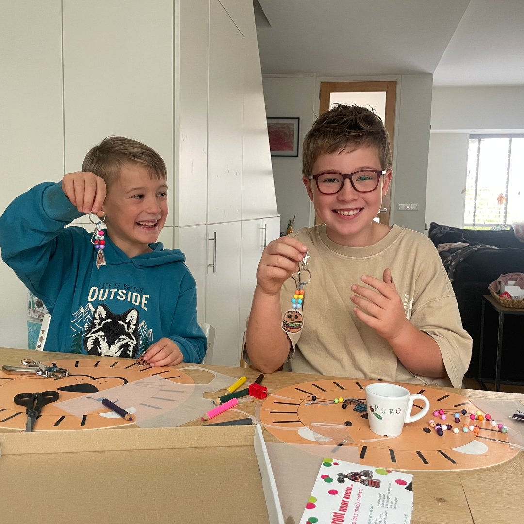 Aaron en Harvey maken sleutelhangers van krimp folie met de kids box.