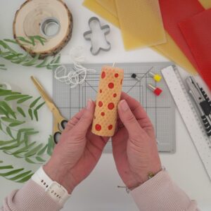 Maak een kaars van bijenwas in het geel met rode stippen.