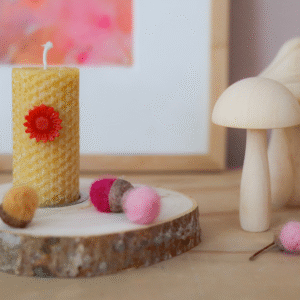 Gele kaars met rood 3D bloemetje in herfst sfeer.